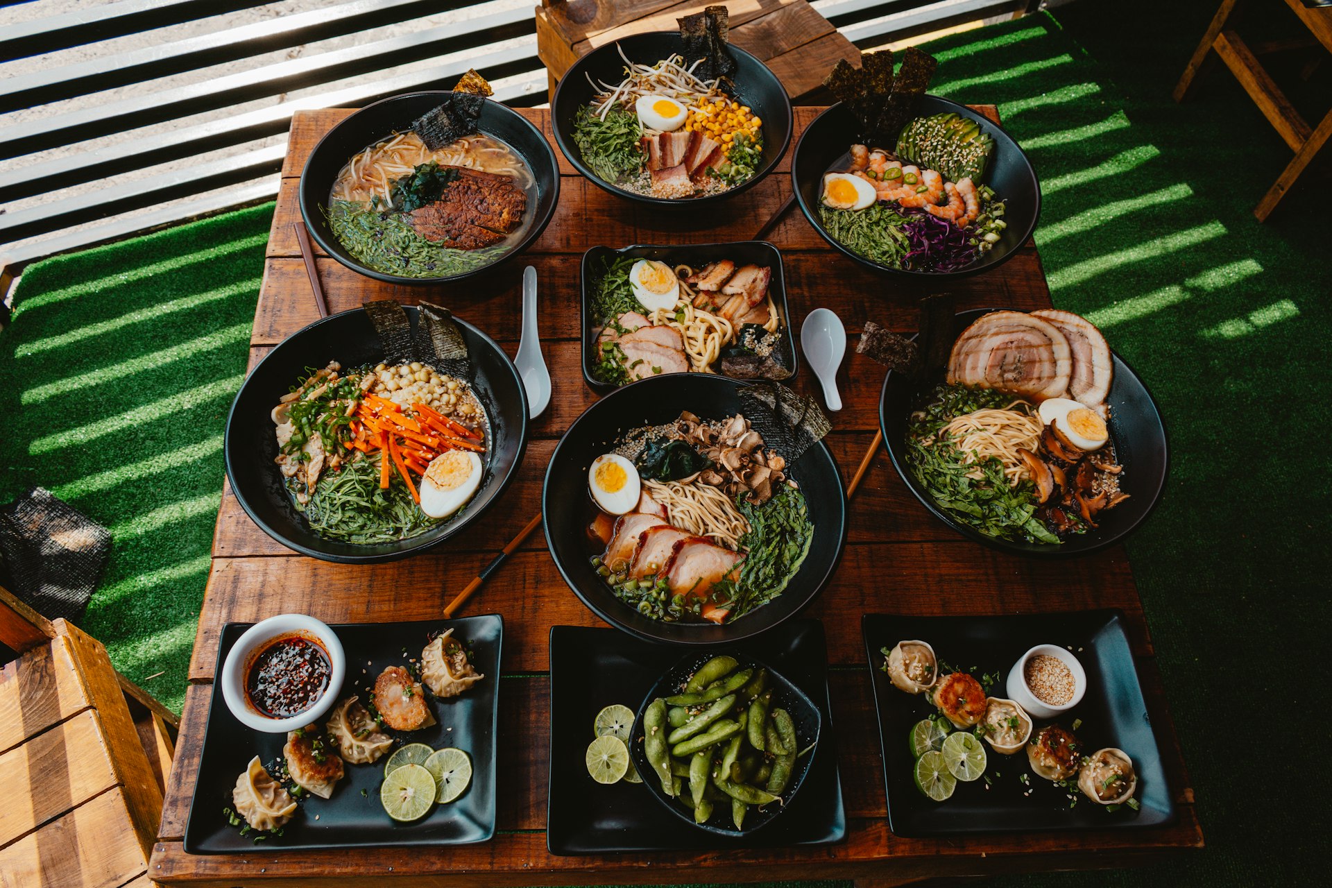 A wooden table topped with lots of plates of food